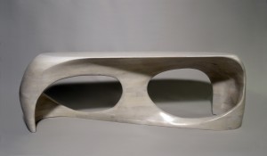Photo of a hand-sculpted bench made of bleached cherry wood, seen from the front