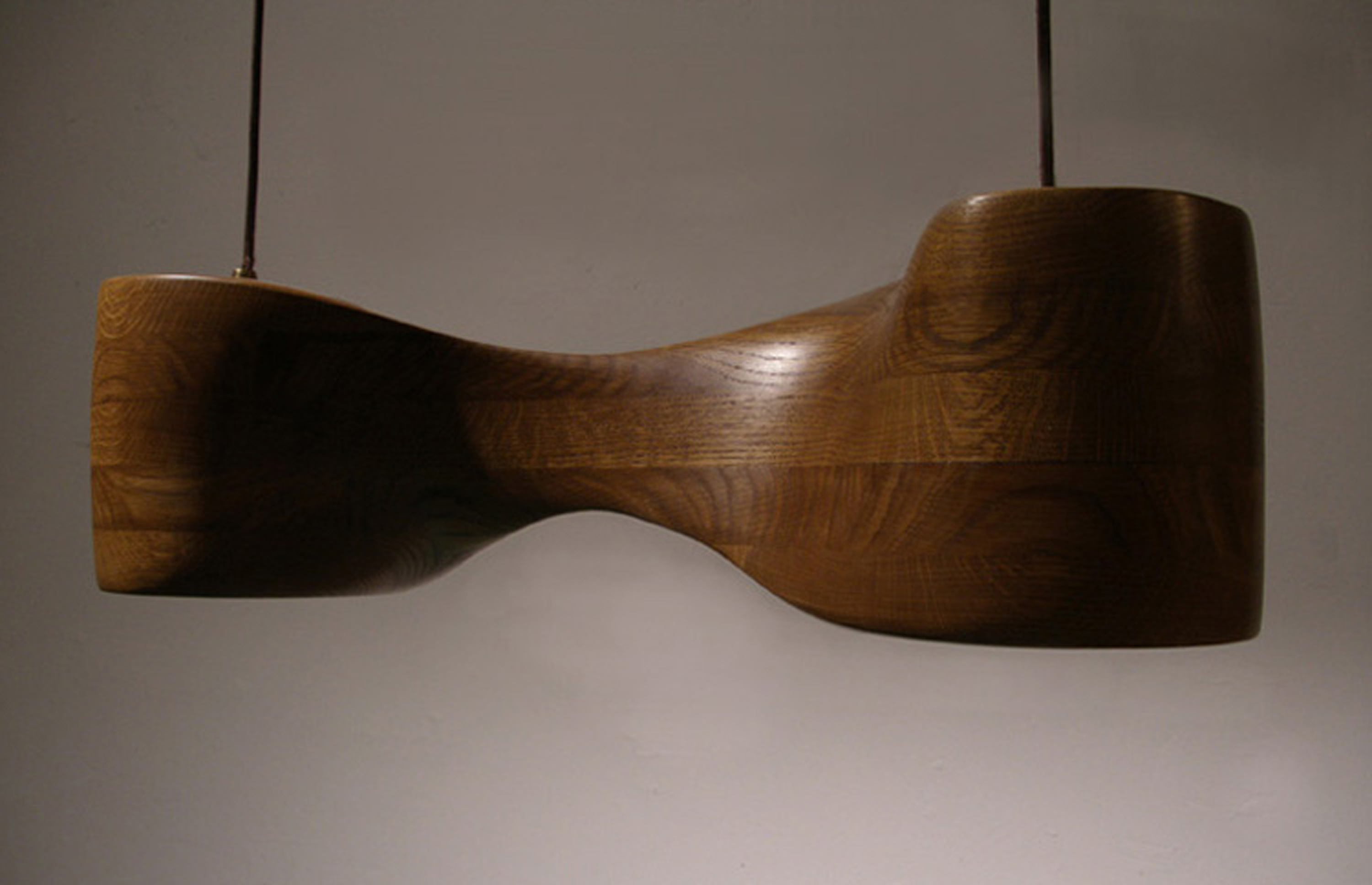 Pendant lamp in oak, sculpted by hand, shown from straight on