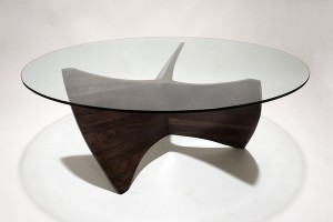 Photo of a propellor-like coffee table base made from walnut with a circular glass top