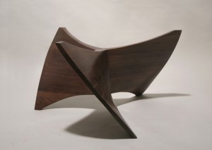 This is a photo of a sculpted wood base for a coffee table made from walnut, seen from the front