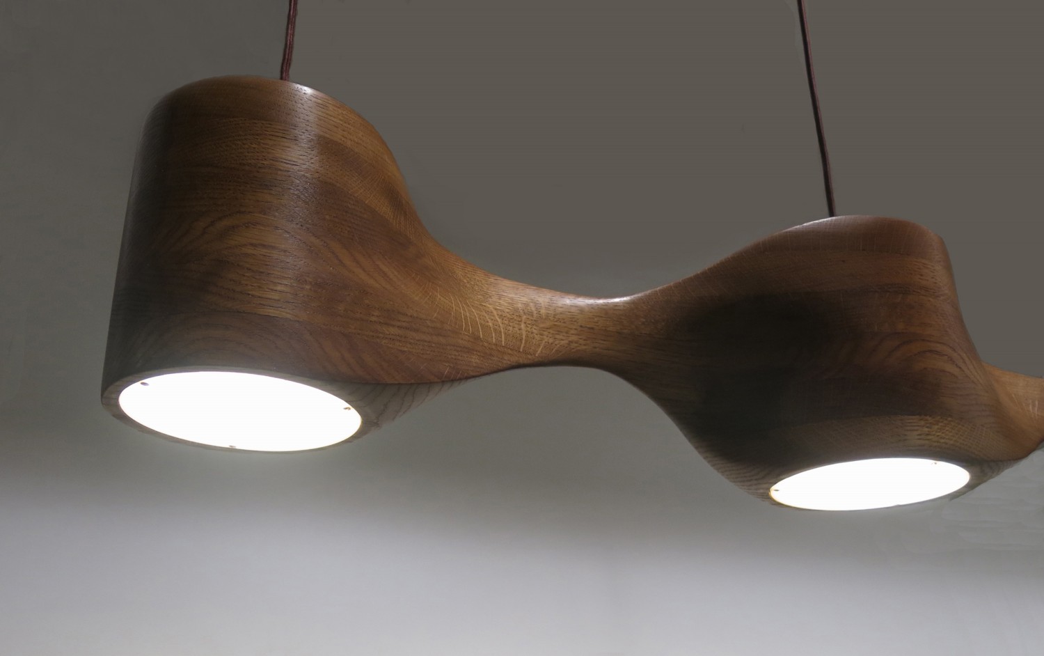 Close up view of a hand-sculpted pendant lamp made from oak