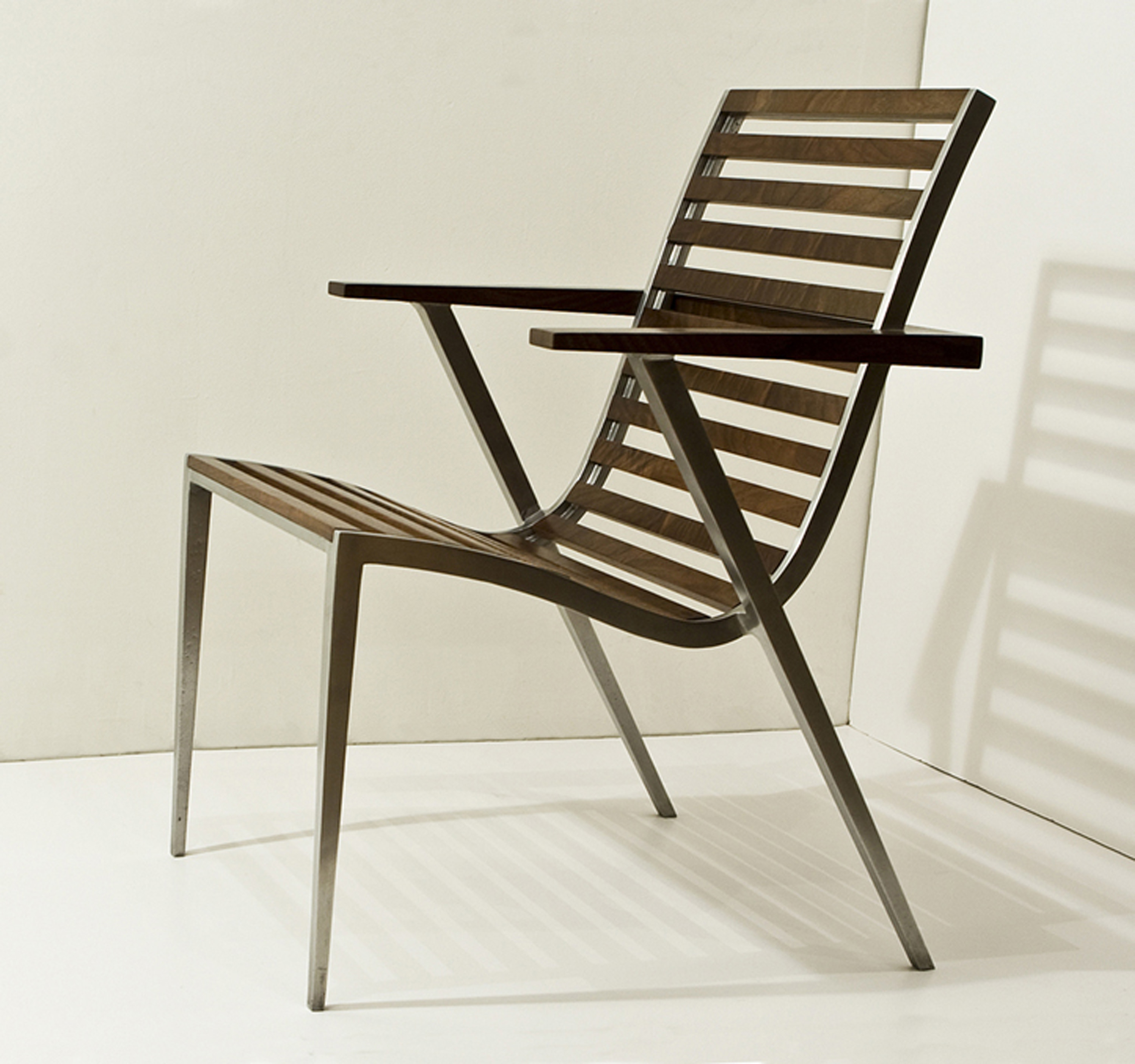 This is a photo of an aluminum and walnut dining chair seen from three-quarters view